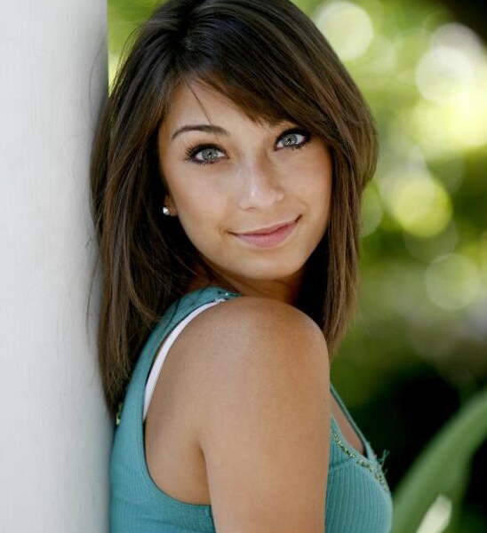 Close-up senior portrait of a girl leaning against a white column